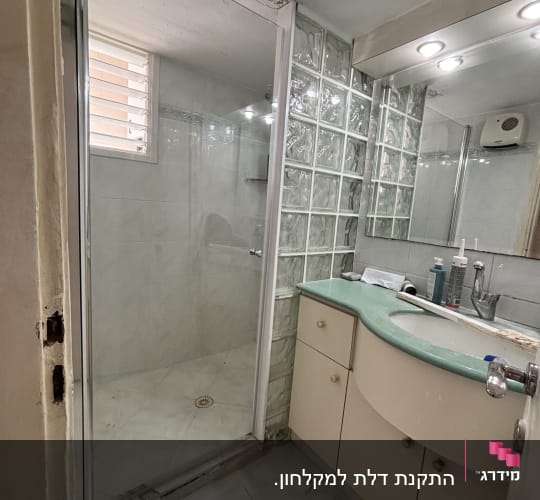 חדר אמבטיה עם מקלחת, כיור ומראה